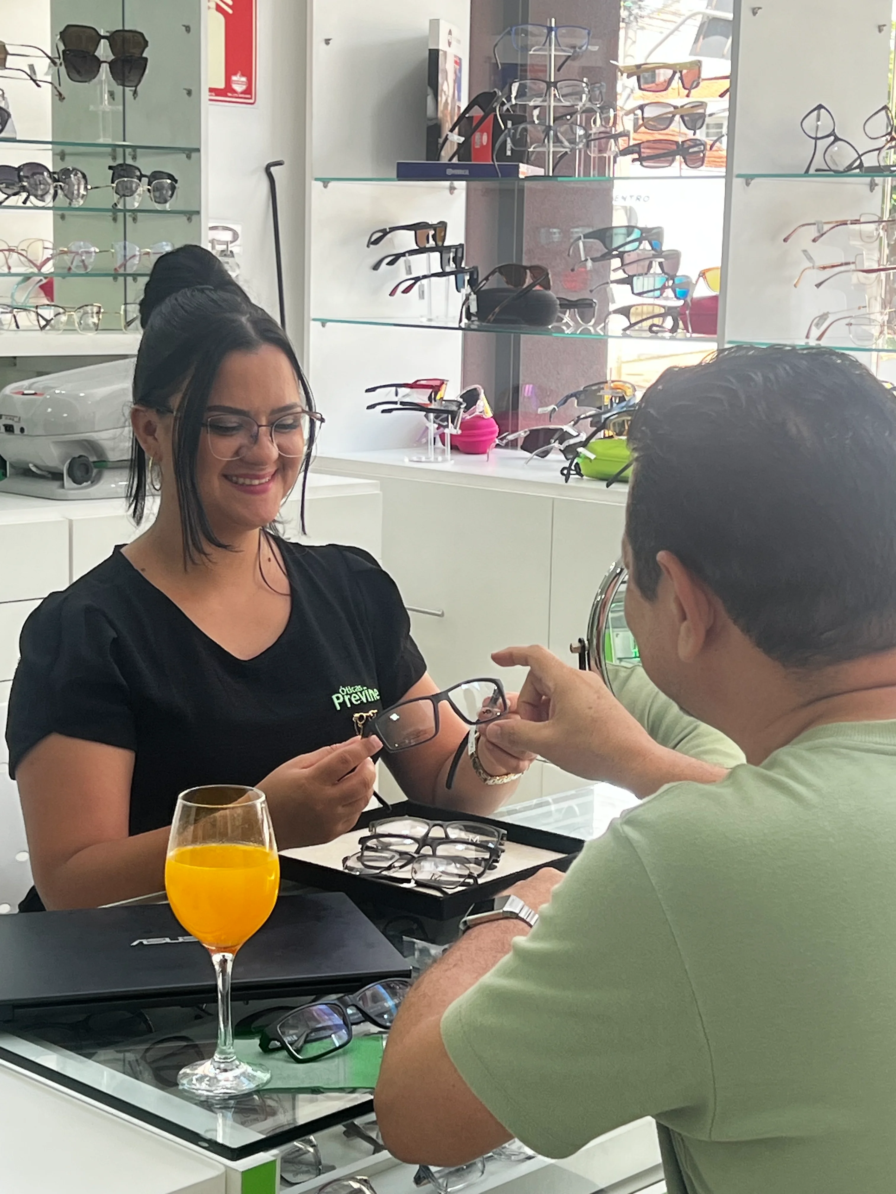 Atendente da Óticas Previne atendendo cliente com atenção